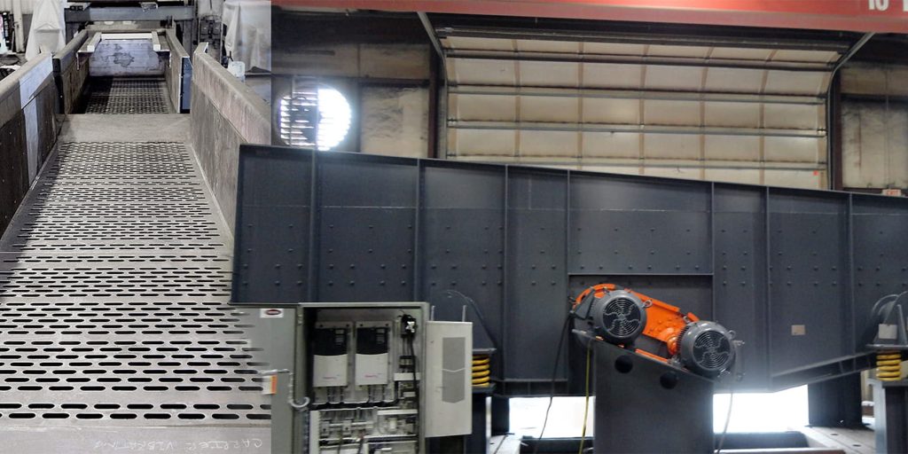 Industrial workshop with a perforated metal walkway and large gray machinery, including orange motor hubs on the right.
