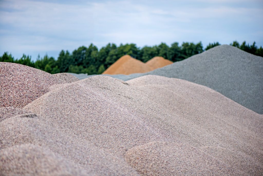 Grands tas de sable et de gravier de construction utilisés pour la production d'asphalte et la construction. Carrière de calcaire, extraction de roches et de pierres